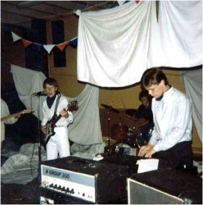 (Fetch) The Comfy Jigsaw "live" at Wood End Youth Centre in September 1981. The photo shows (left to right): Matthew Lees (guitar), Mark Mortimer (bass and on this song lead vocals!), Donald Skinner (drums) and Andrew Baines playing keyboards (he also played guitar).